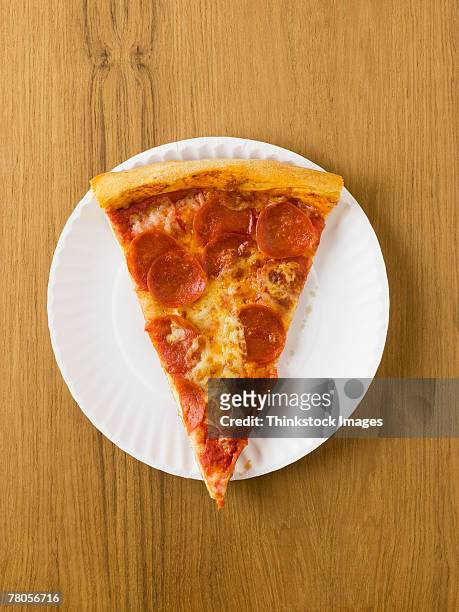 slice of pizza on a paper plate - papieren bord stockfoto's en -beelden