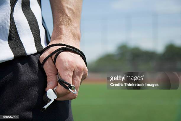 referee's hand holding whistle - árbitro fotografías e imágenes de stock