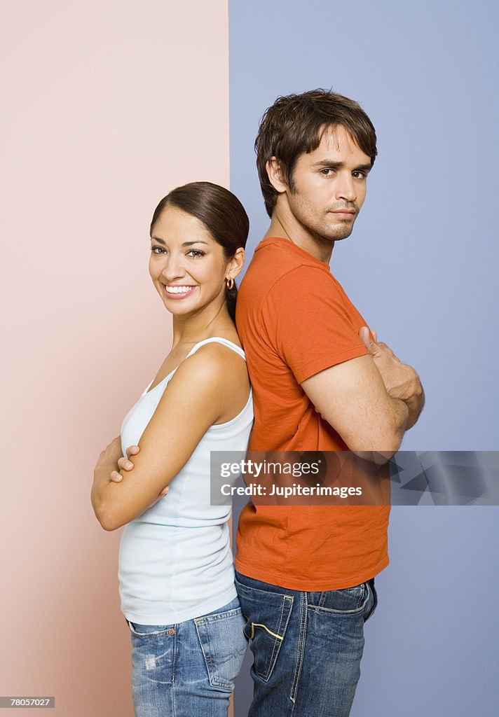 Woman and man standing back to back