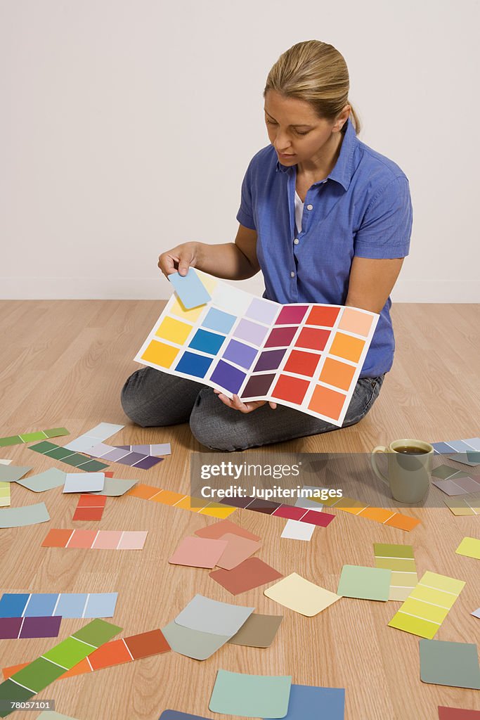Woman sitting on floor with paint samples
