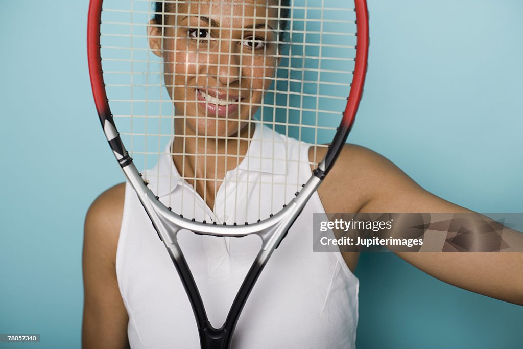 Female tennis player looking through tennis