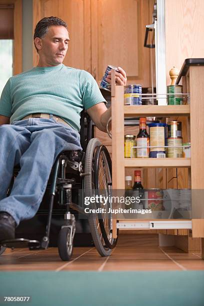 man in wheelchair in kitchen - voorraadkast stockfoto's en -beelden