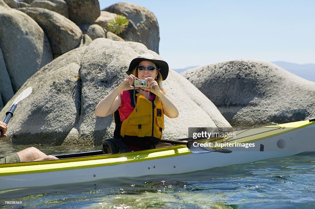 Woman taking a picture in a kayak