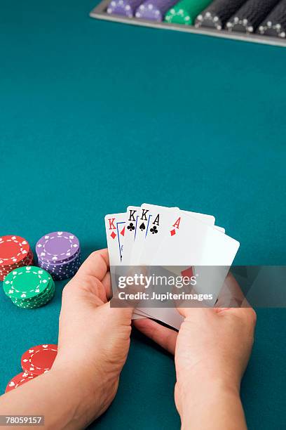 hand holding poker cards - volles haus stock-fotos und bilder