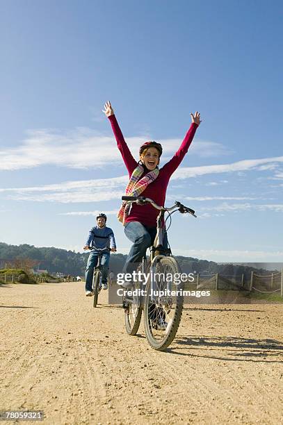 woman riding bike with no hands on handlebars - freihändiges fahrradfahren stock-fotos und bilder