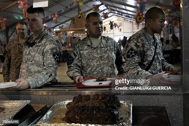 Soldiers line up to receive their turkey dinner during Thanksgiving celebrations in Warhorse US army base in Baquba, northeastern Baghdad, 22...