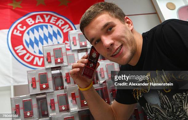 Lukas Podolski poses with the new Bayern Munich Sony Ericsson Mobile Phone at Bayern's training ground Saebener Strasse, on November 22, 2007 in...