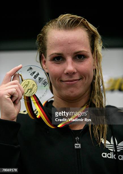 Britta Kamrau-Corestein of SC Empor Rostock poses for a photo with her gold medal after winning the women's 1500m free style final during the German...