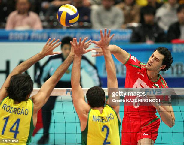 Bulgarian attacker Matey Kaziyski spikes the ball against Brazilian blockers, Rodrigo Santana and Marcelo Elgarten during a match of the FIVB Men's...