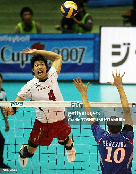 Japan's Kunihiro Shimizu jumps for the spike in front of Russia's Yury Berezhko during the FIVB men's World Cup volleyball tournament second phase in...