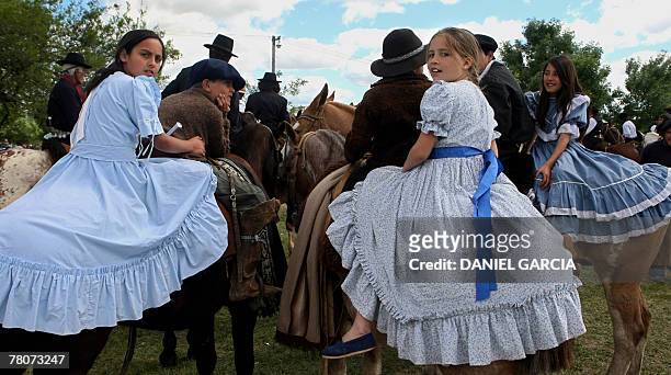 Female Gauchos, better known as "Chinitas", wait on their horses for the start of a gaucho's parade during the Tradition Day, in San Antonio de...