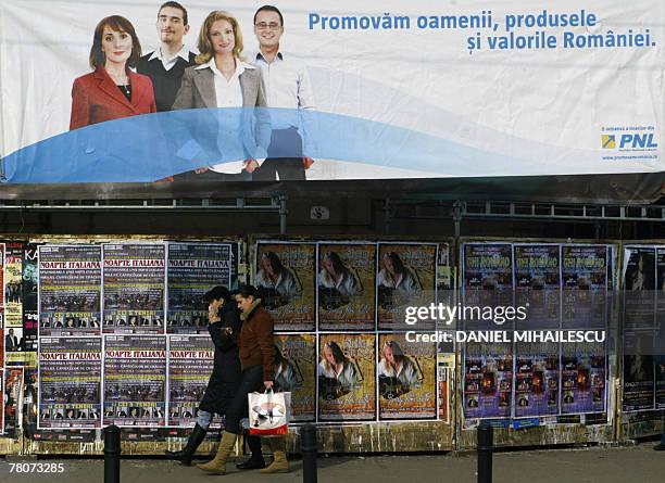 Romanian people walk under a National Liberal Party banner, reading: "We promote the people and the values of Romania," and showing portraits of PNL...