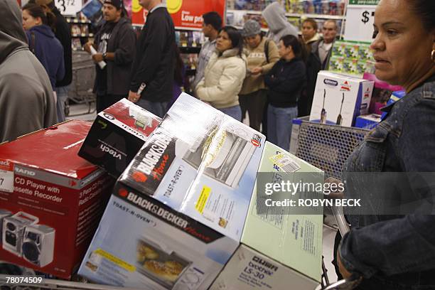 An early morning shopper pushes her cart full of items at a Wal-Mart store which opened its doors at 5:00am, in Panorama City, California, 23...