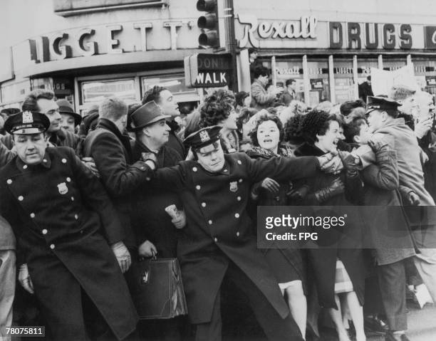 Police restraining an excitable crowd, New York City, circa 1963.