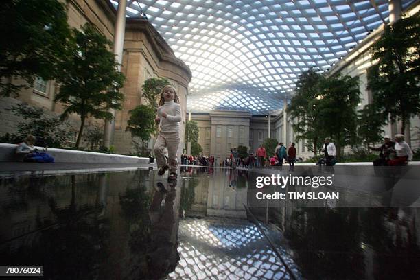 Children play at the new Robert and Arlene Kogod Courtyard, with its elegant glass canopy designed by world renowned architect Norman Foster opened...