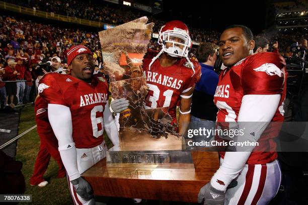 Members of the Arkansas Razorbacks celebrate with 'The Boot' trophy after defeating the ranked Louisiana State University Tigers in triple overtime...