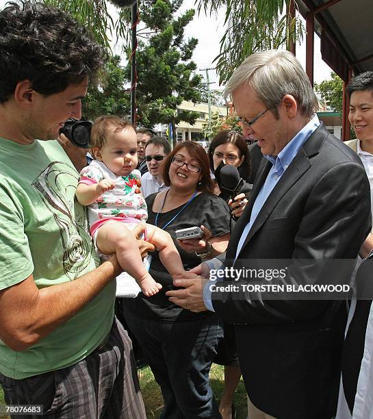 Opposition Labor leader Kevin Rudd shares a joke with a supporter after voting with his wife, Therese Rein , in Rudd's home electorate of Griffith in...