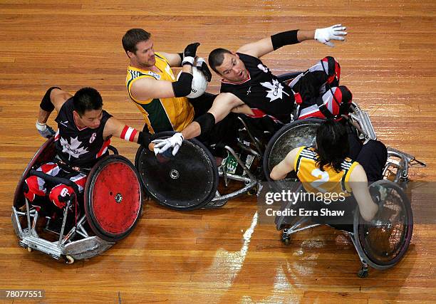 Greg Smith of Australia is defended by Ian Chan and Mike Whitehead of Canada during the 2007 Oceania Wheelchair Rugby Championships Final between...