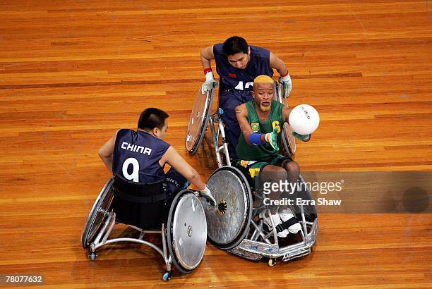 Eric Diamini of South Africa passes the ball while guarded by Yu Zhong Tao and Shao De Quan of China during the 2007 Oceania Wheelchair Rugby...
