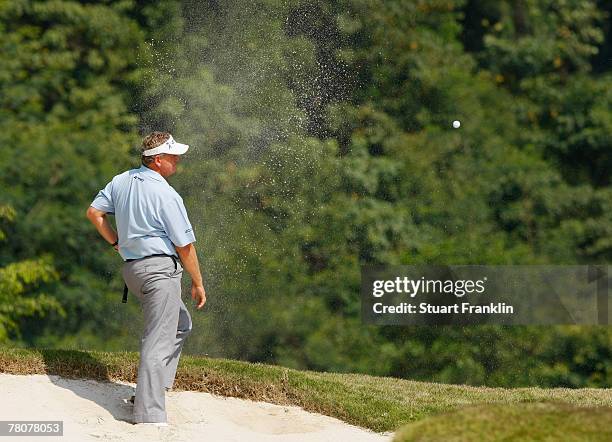 Colin Montgomerie of Scotland watches his bunker shot on the fourth hole during the third round of the Omega Mission Hills World Cup at the Mission...