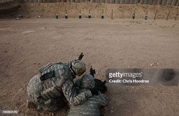 Member of the 2-69 Armored Battalion of the 3rd Infantry Division advises another on shooting technique during target practice November 24, 2007 in...