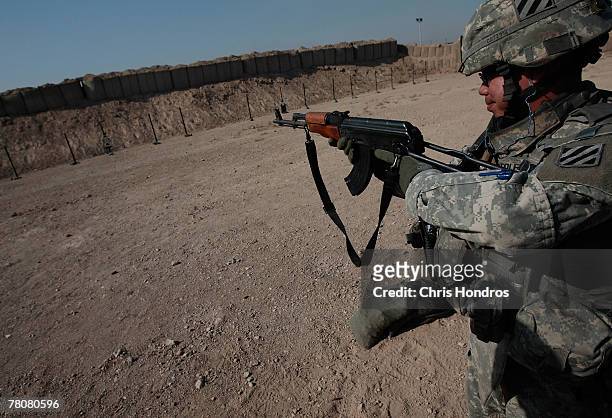 Member of the 2-69 Armored Battalion of the 3rd Infantry Division fires the AK-47 assault rifle during target practice November 24, 2007 in Baghdad,...