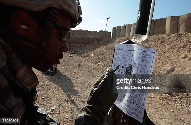Spc. Otis Kinman of Newark, New Jersey in the 2-69 Armored Battalion of the 3rd Infantry Division looks over his target during target practice...