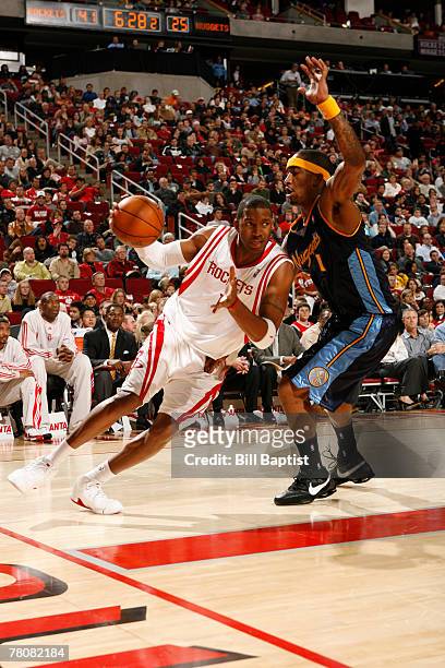 Tracy McGrady of the Houston Rockets dribbles the ball past J.R. Smith of the Denver Nuggets on November 24, 2007 at the Toyota Center in Houston,...