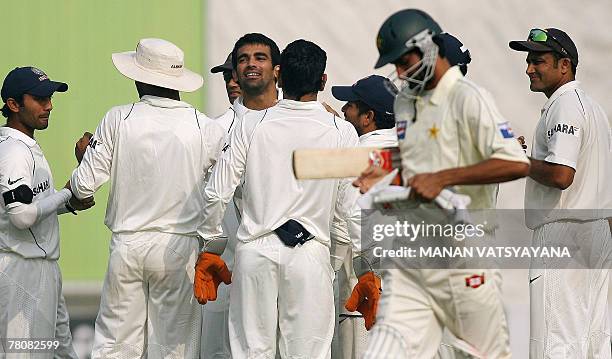 Indian cricketer Zaheer Khan celebrates with teammates after taking the wicket of Pakistan's Sohail Tanveer during the fourth day of the first Test...