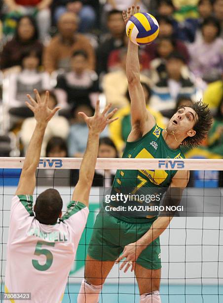Brazilian volleyball star Gilberto Godoy Filho "Giba" spikes the ball over Australian blocker Luke Campbell during their match at the FIVB Men's...