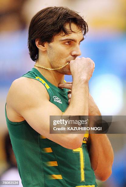 Brazilian volleyball star Gilberto Godoy Filho "Giba" holds his pendant in his mouth before the start of his team's match against Australia at the...