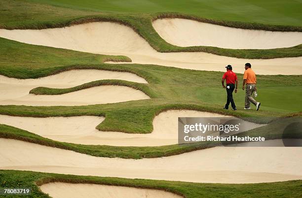 Andres Romero and Ricardo Gonzalez of Argentina walk amoungst bunkers on the 10th during the final round of the Omega Mission Hills World Cup at the...