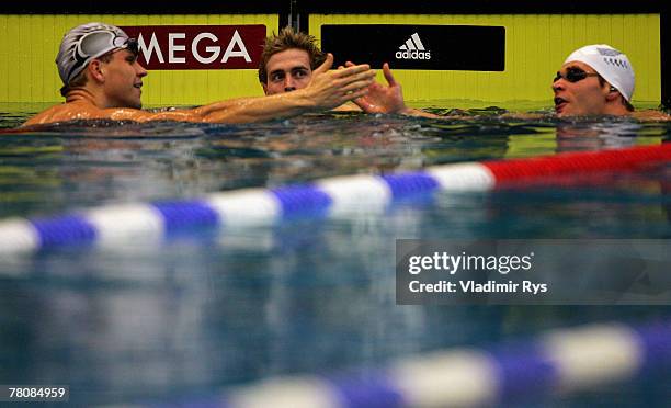 Denes Schroeder of SG Berline Wasserratten , Helge Meeuw of SG Frankfurt and Robert Koenneker of SG Dortmund react after the 100m backstroke final...