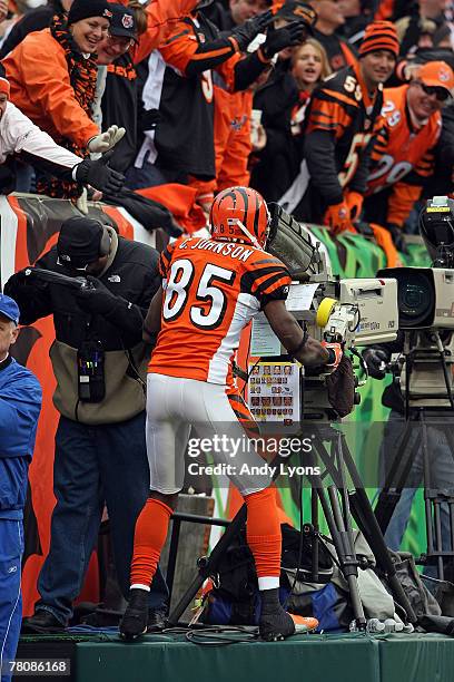 Chad Johnson of the Cincinnati Bengals celebrates after catching a touchdown pass by taking over a television camera during the NFL game against the...
