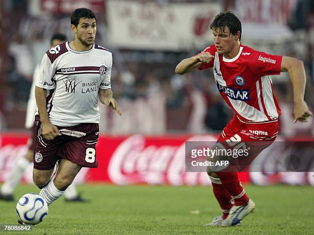 Lanus' Diego Valeri is marked by Roberto Battion of Argentinos Juniors, during their Argentina first division football match, in Buenos Aires, 25...