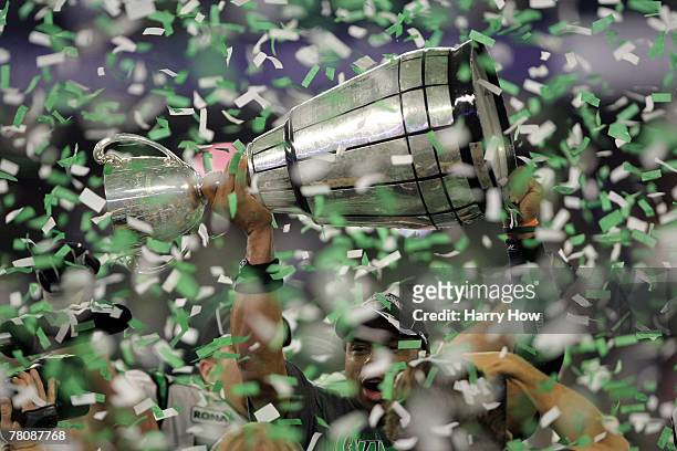 Quarterback Kerry Joseph of the Saskatchewan Rough Riders hoists the trophy as confetti falls in celebration of a 23-19 victory over the Winnipeg...