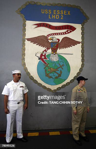 Sailors stand in front of the USS Essex's logo as she arrived at Sihanouk Ville town, some 220 kilometers southwest of Phnom Penh, 26 November 2007....