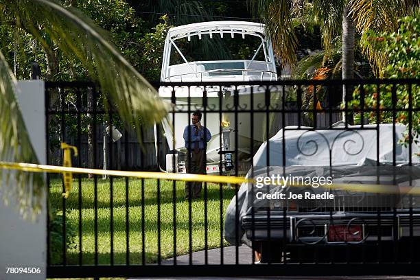 An investigator stands in the yard of the home where an intruder shot Washington Redskins football player Sean Taylor in the leg November 26, 2007 in...