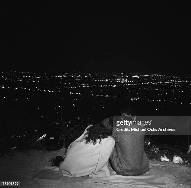 Couple sit and take in the view on Mulholland Drive overlooking the city at night on June 7 1951 in Los Angeles California.