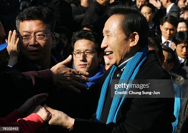 Presidential candidate Lee Myung-Bak of the conservative main opposition Grand National Party, shakes hands with his supporters during presidential...