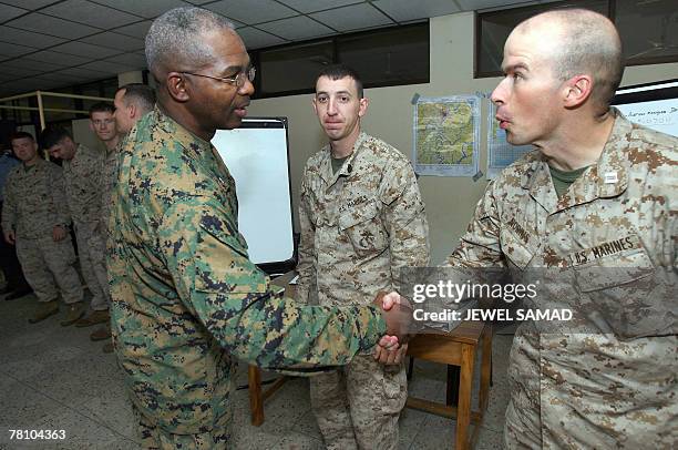Brigadier General Ronald Biley shakes hands with a Marine at the Barishal airport-turned-military base in Barishal, 27 November 2007. US marines and...