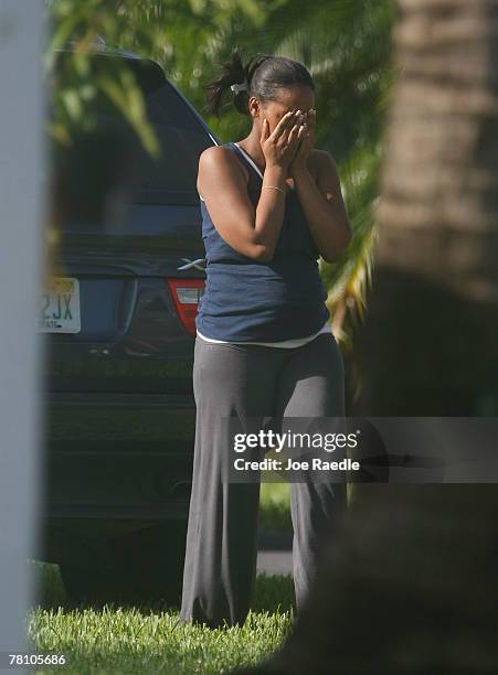 Women covers her face as she cries after arriving in front of the home where an intruder shot and killed Washington Redskins football player Sean...