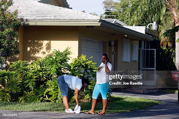 People stand in front of the home where an intruder shot and killed Washington Redskins football player Sean Taylor November 27, 2007 in Miami,...