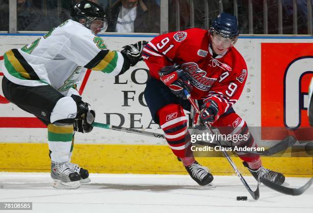 John Tavares of the Oshawa Generals tries to fire a shot around the coverage of Andrew Wilkins of the London Knights in a game on November 23, 2007...