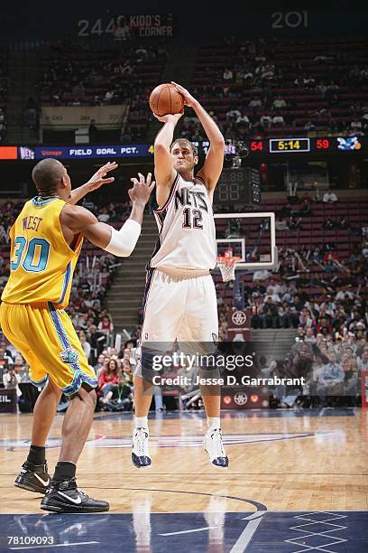 Nenad Krstic of the New Jersey Nets takes a jump shot against David West of the New Orleans Hornets during the game on November 12, 2007 at the Izod...