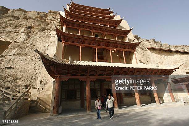 China-heritage-archaeology-religion-Mogaoby Dan Martin Visitors walk outside the Mogao Grottoes Buddhist mural complex in remote Gansu province in...