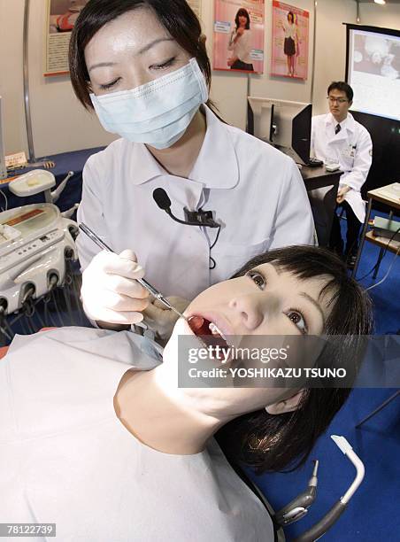 Japan's Nippon Dental University Hospital staff Yuko Uchida demonstrates a humanoid robot dental therapy simulator "Simroid" for dentists and...