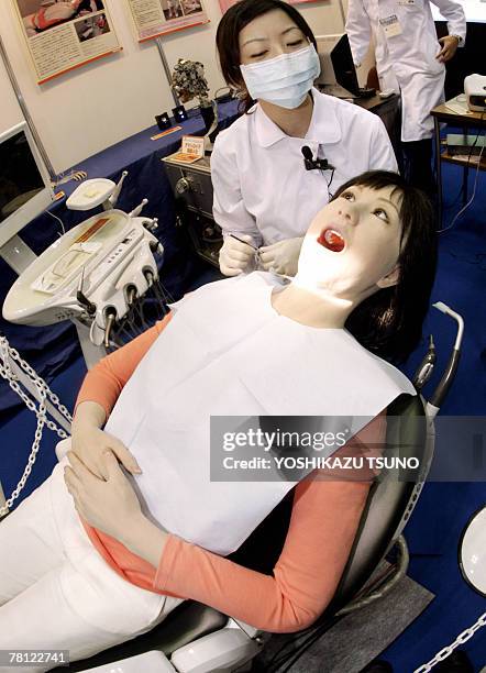 Japan's Nippon Dental University Hospital staff Yuko Uchida demonstrates a humanoid robot dental therapy simulator "Simroid" for dentists and...