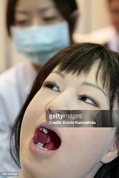 Trainee dentist treats a dental patient robot "Simroid" by Kokoro Company Ltd during the 2007 International Robot Exhibition at Tokyo Big Site on...