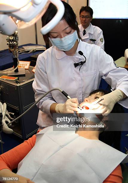 Trainee dentist treats a dental patient robot "Simroid" by Kokoro Company Ltd during the 2007 International Robot Exhibition at Tokyo Big Site on...